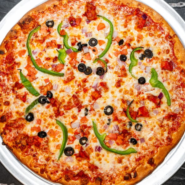 A whole Halal Krush pizza with melted cheese, green peppers, black olives, and red onions.